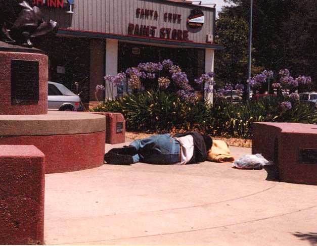 A homeless man sleeps on the sidewalk in Santa Cruz. Almost no thought is being given to all those left without shelter.  