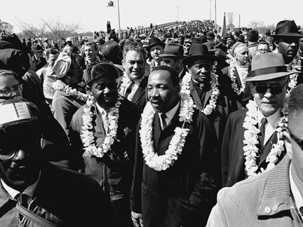 This March 21, 1965, AP photo shows Martin Luther King, Jr. and civil-rights marchers crossing the Edmund Pettus Bridge in Selma, Alabama, heading for the capitol in Montgomery. (Photo credit: AP file)