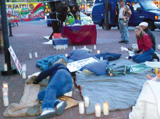 Demonstrators spread out blankets and sleeping bags and hold a nighttime vigil in downtown Berkeley to protest the criminalization of homelessness and sleeping by the Berkeley City Council.. Lydia Gans photo