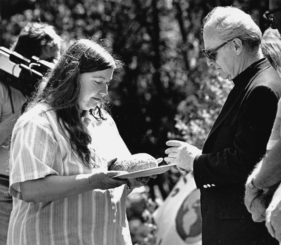 Shelley Douglass shares bread with Archbishop Raymond Hunthausen at peace vigil on the railroad tracks at the Bangor Naval Base, in protest of Trident submarines.