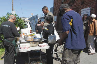 Every Thursday, Joe Liesner and Food Not Bombs volunteers serve a warm meal to the recyclers. Lydia Gans photo
