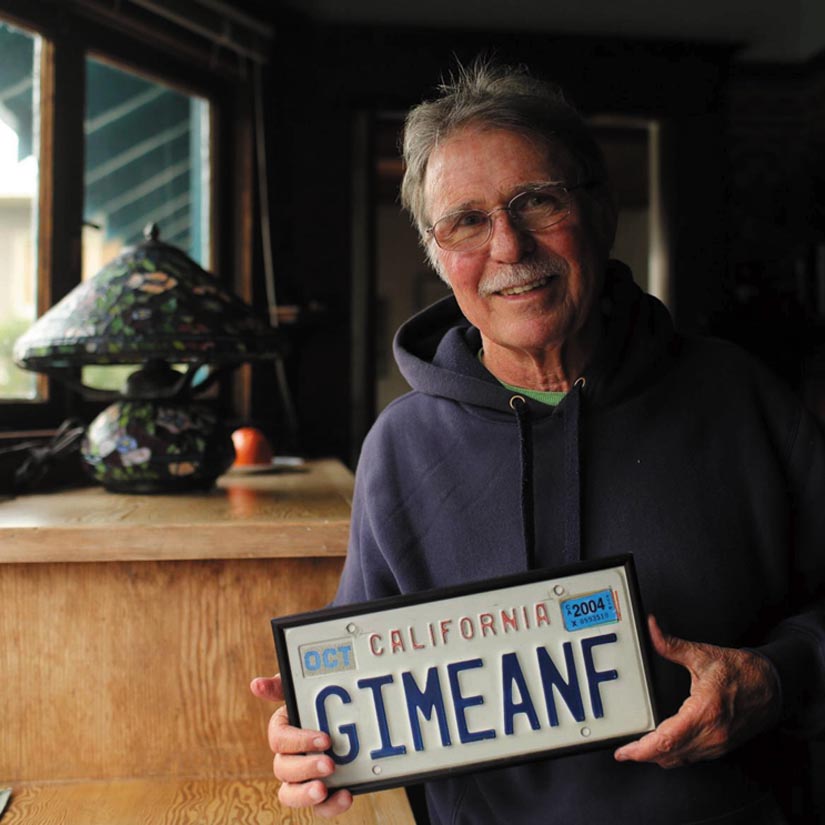 Country Joe McDonald smilingly displays his “Give Me an F” license plate.