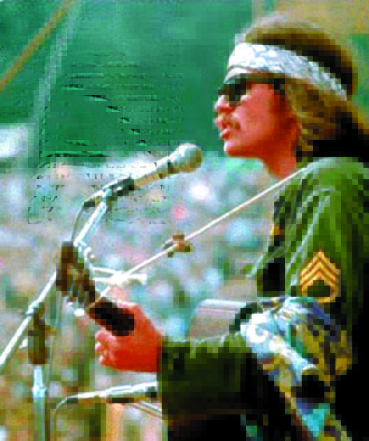 Country Joe McDonald sings “Next stop is Vietnam” with 300,000 people at Woodstock.