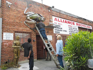 Workers take down the beautiful metal frog sculpture as Alliance Recycling closes its doors for the last time. Lydia Gans photo