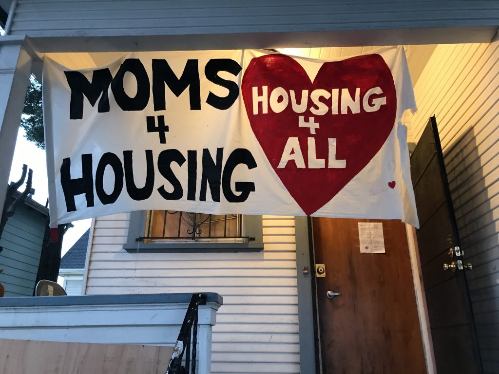 A banner hangs over the Moms 4 Housing home on Magnolia Street after the moms were evicted.