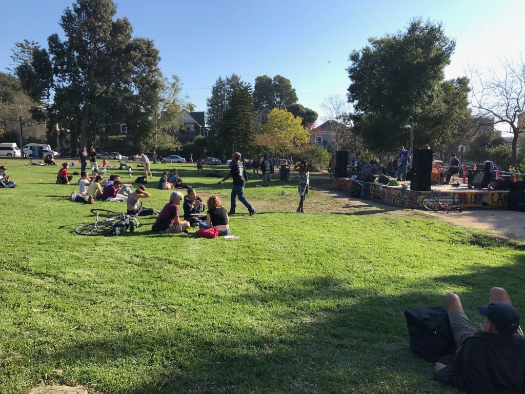 Concertgoers lounging in the grass at Berkeley's People’s Park. 