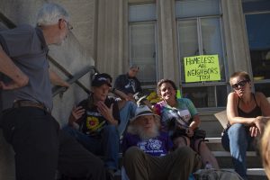 Protestors sit on the steps of Berkeley City Hall.
