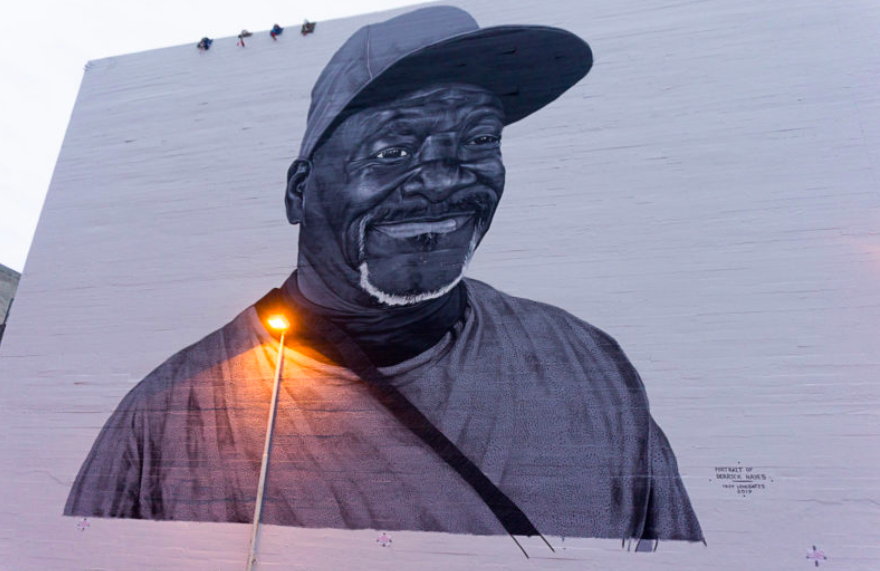 A large portrait of Derrick Hayes is painted on a wall in Downtown Oakland.