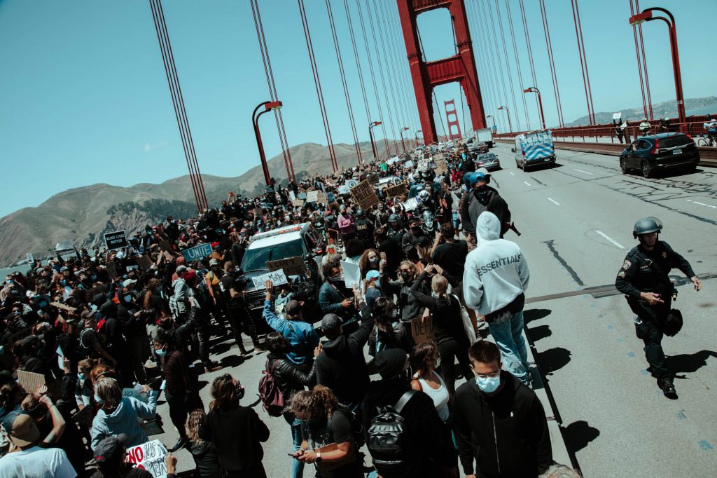 A dense group of protestors stand in the southbound lanes of the golden gate bridge. The northbound lanes remain free of protestors, for now.