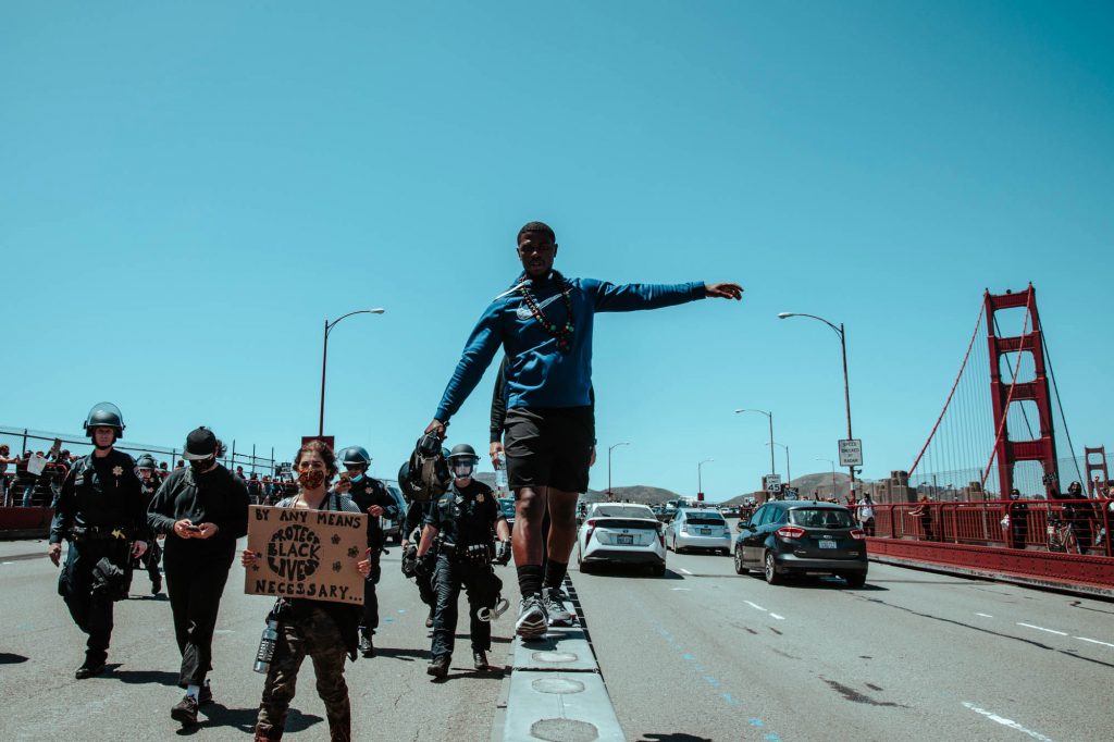 A protestor walks on the median of the Golden Gate Bridge with a megaphone.
