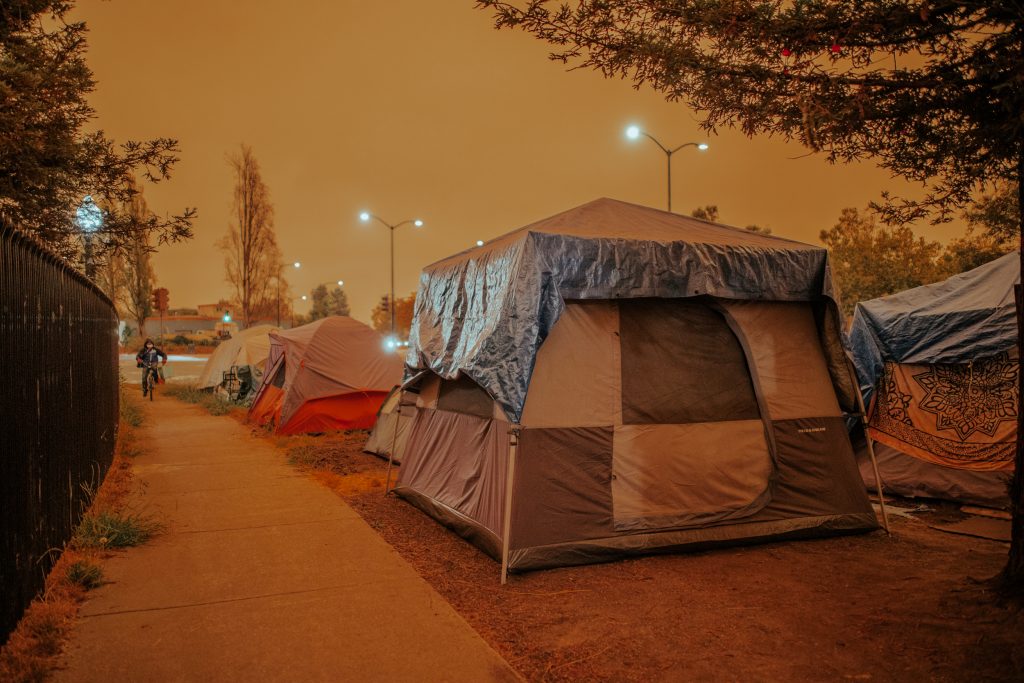 An eerie glow engulfs South Berkeley's Here/There encampment on Wednesday as wildfires rage in California.