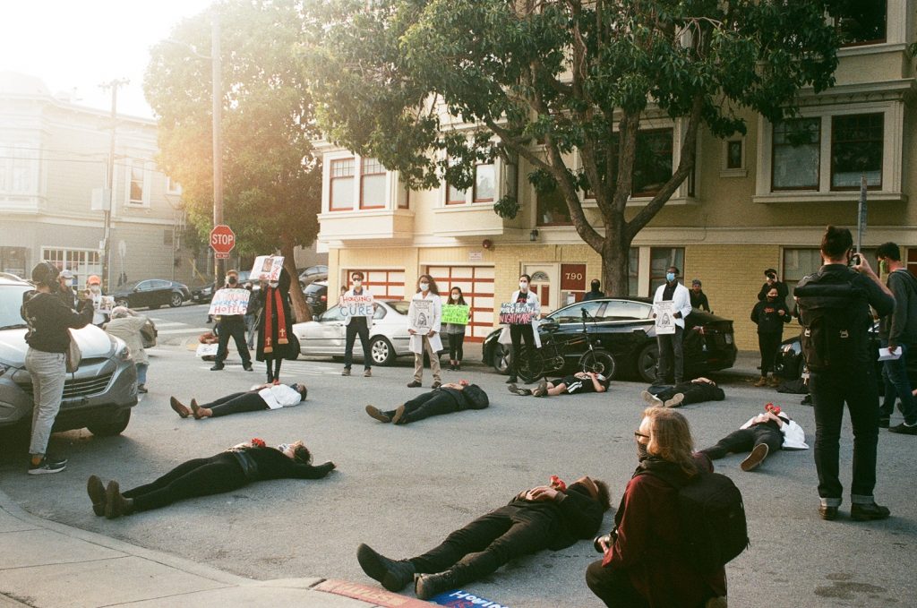 Protestors lie down in the street wearing all black during a "die-in" protest outside SF Mayor London Breed's home.