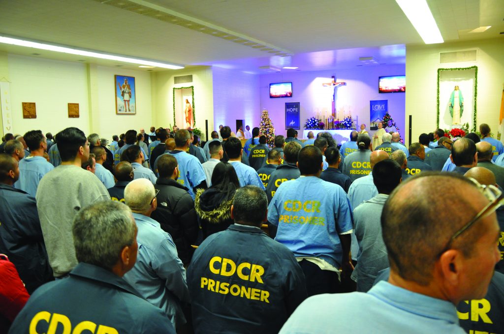 Christmas inside the chapel at San Quentin. The words "CDCR Prisoner" can be seen on the back of the men's shirts.
