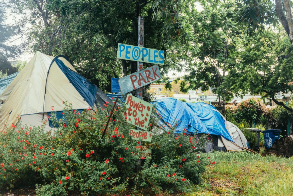 Tents can be seen behind a series of hand made signs that read, "people's park, power to the people"