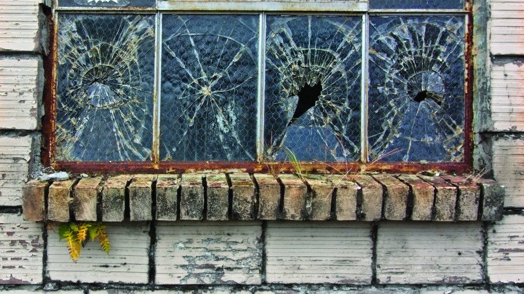 A window pane containing four broken windows.