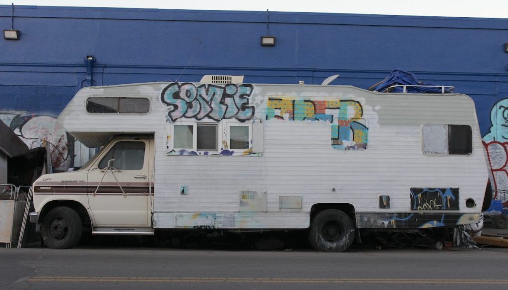 A picture of an RV in profile against a blue wall.