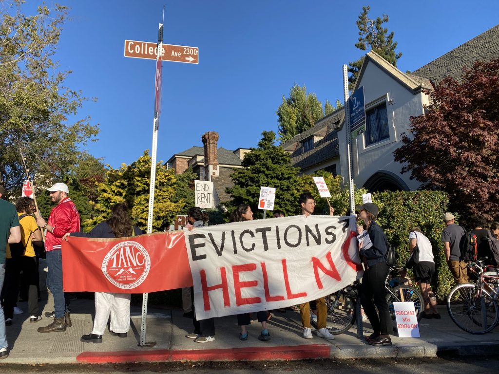 Members of Tenant and Neighborhood Councils hold a banner outside Freehouse reading "Evictions, Hell No!"
