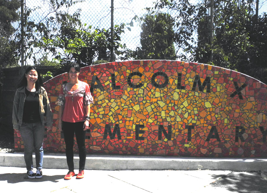 YSA staff Lia Li and Danielle Gibbins in front of the Malcolm X Elementary School mural in Berkeley. Carol Denney photo