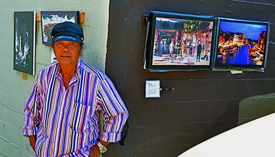 The homeless artist proudly displays his paintings at a streetside art gallery he created himself. Robert L. Terrell photo