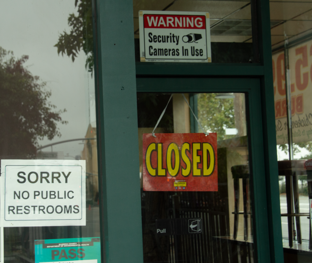 A sign reading "sorry, no public restrooms" is posted on a restaurant door.