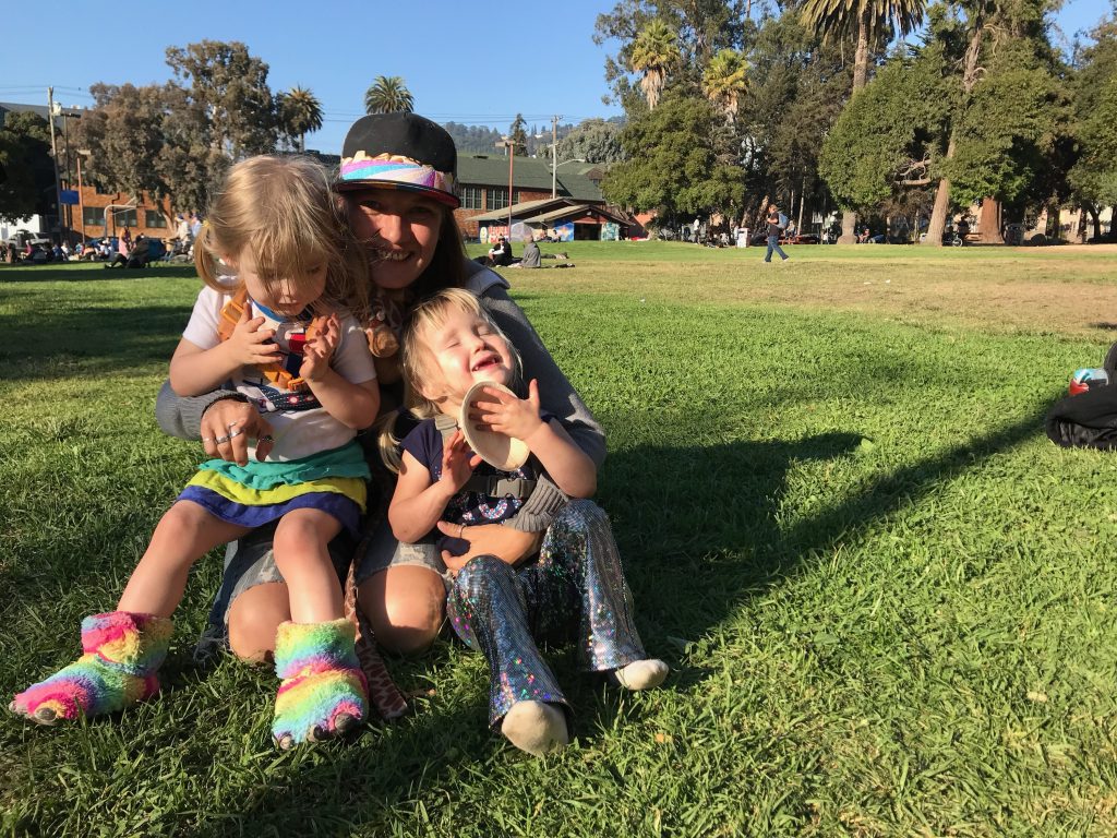 Mandy ‘Danger’ and her daughters Parker (L) and Aurora sit in the grass at People's Park.