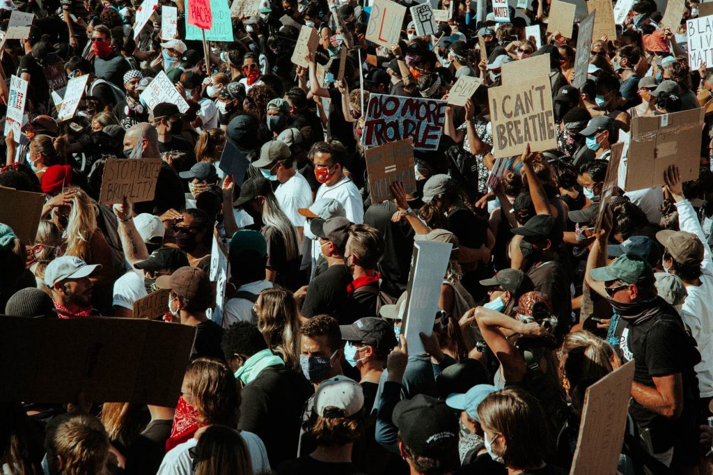 A dense crowd of protestors fills the whole frame of the photograph. The crowd is marching marches down San Francisco's 18th Street.