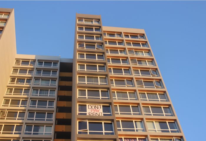 A photo of 1130 3rd avenue: a high rise apartment building with a sign in one unit's window that says "don't pay rent."